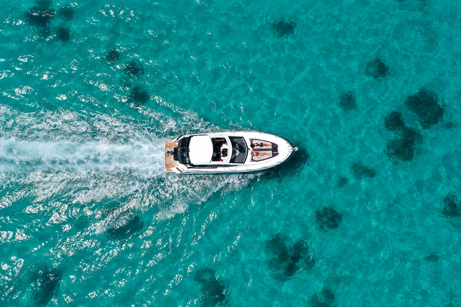 An overhead drone view of Maga Kani cruising through turquoise water